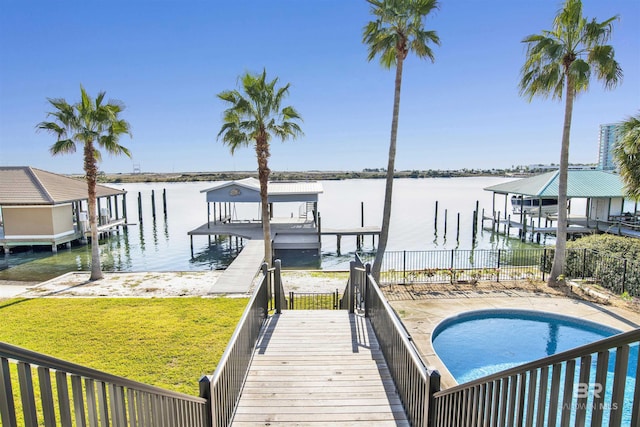 view of dock with a lawn, a water view, and a fenced in pool