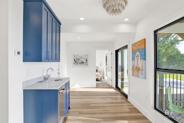 hall featuring light hardwood / wood-style flooring, a healthy amount of sunlight, and sink