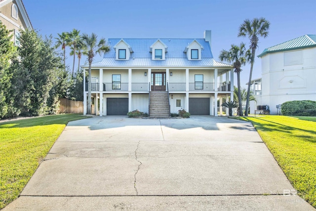 view of front of property with french doors, a front lawn, covered porch, and a garage