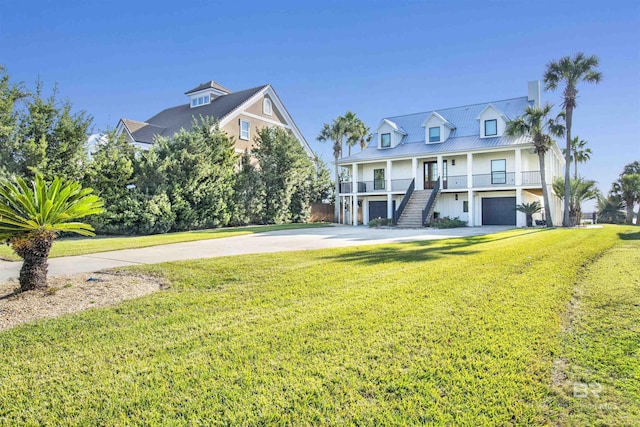 view of front of house featuring a garage, covered porch, and a front lawn