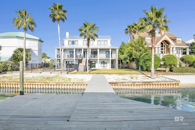 rear view of property featuring a water view and a balcony