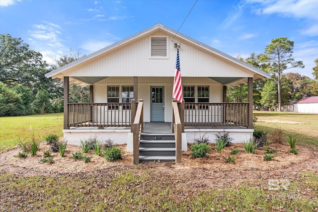 bungalow featuring covered porch and a front lawn