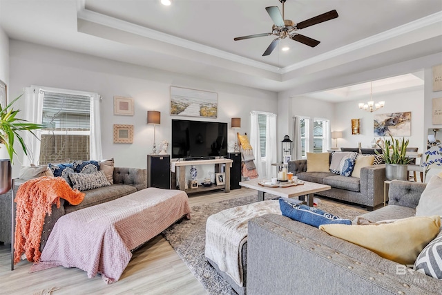 3905 Mercury Cir, Gulf Shores, AL 36542 - living room with light wood finished floors, ceiling fan with notable chandelier, ornamental molding, and a tray ceiling