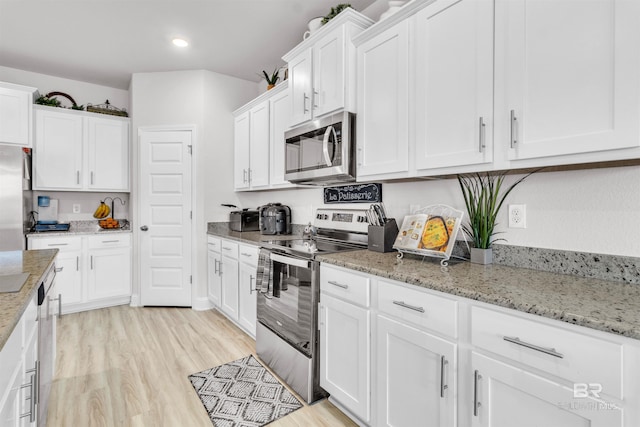 3905 Mercury Cir, Gulf Shores, AL 36542 - kitchen with light wood finished floors, stainless steel appliances, white cabinetry, light stone countertops, and recessed lighting