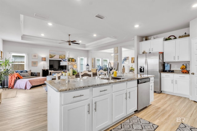 3905 Mercury Cir, Gulf Shores, AL 36542 - kitchen with an island with sink, a sink, open floor plan, a raised ceiling, and appliances with stainless steel finishes