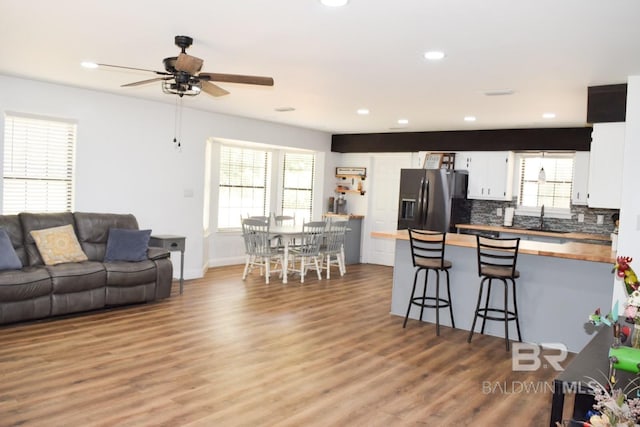 living room with ceiling fan, sink, and hardwood / wood-style floors