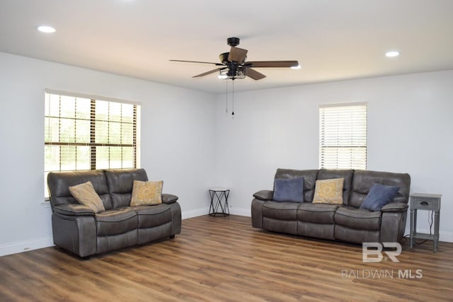 living room with dark hardwood / wood-style flooring and ceiling fan