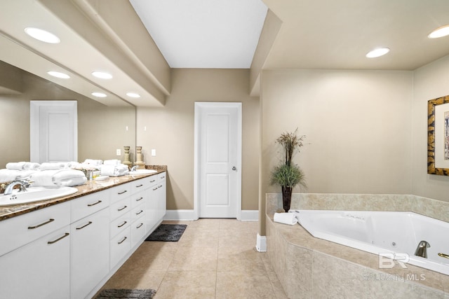 bathroom with double vanity, tile patterned flooring, a jetted tub, and a sink