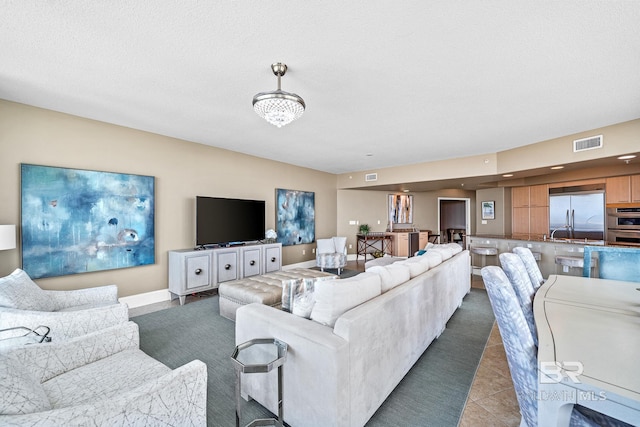 living area featuring tile patterned flooring and visible vents