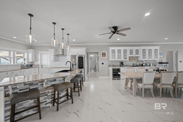 2420 Bienville Blvd, Dauphin Island, AL 36528 - kitchen with appliances with stainless steel finishes, recessed lighting, ornamental molding, beverage cooler, and a kitchen bar