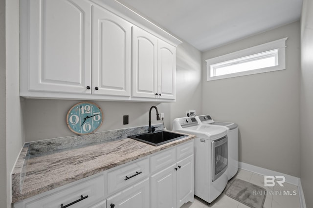 2420 Bienville Blvd, Dauphin Island, AL 36528 - clothes washing area with cabinet space, washer and dryer, light tile patterned floors, and baseboards