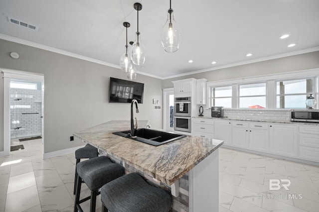 2420 Bienville Blvd, Dauphin Island, AL 36528 - kitchen featuring stainless steel appliances, light marble finish flooring, a sink, ornamental molding, and a kitchen island with sink