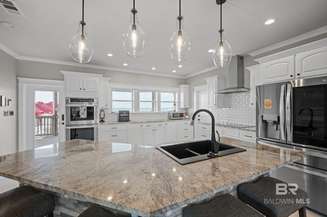 2420 Bienville Blvd, Dauphin Island, AL 36528 - kitchen with wall chimney exhaust hood, appliances with stainless steel finishes, a sink, a breakfast bar area, and healthy amount of natural light