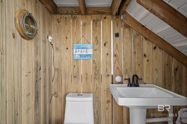 2420 Bienville Blvd, Dauphin Island, AL 36528 - bathroom featuring wooden walls, toilet, and a sink