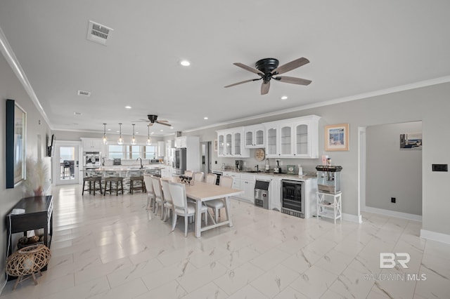 2420 Bienville Blvd, Dauphin Island, AL 36528 - dining area with a ceiling fan, crown molding, wine cooler, recessed lighting, and wet bar