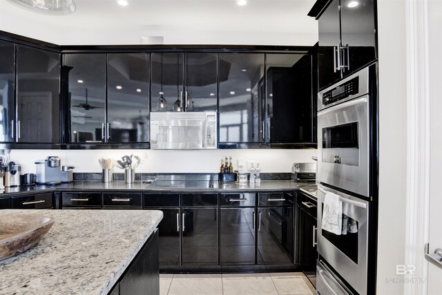 14237 Perdido Key Dr Unit Ph-1401, Pensacola, FL 32507 - kitchen featuring light tile patterned flooring, a warming drawer, appliances with stainless steel finishes, and dark cabinets