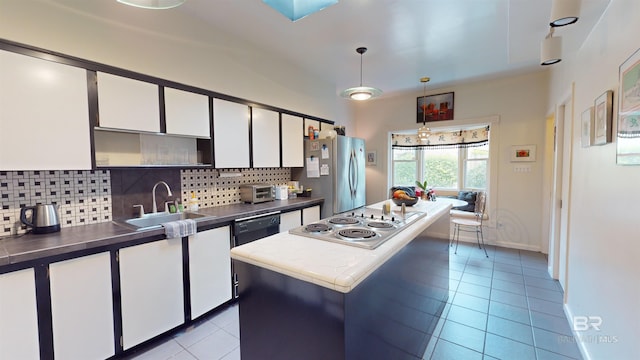 kitchen with pendant lighting, decorative backsplash, white cabinets, and stainless steel appliances