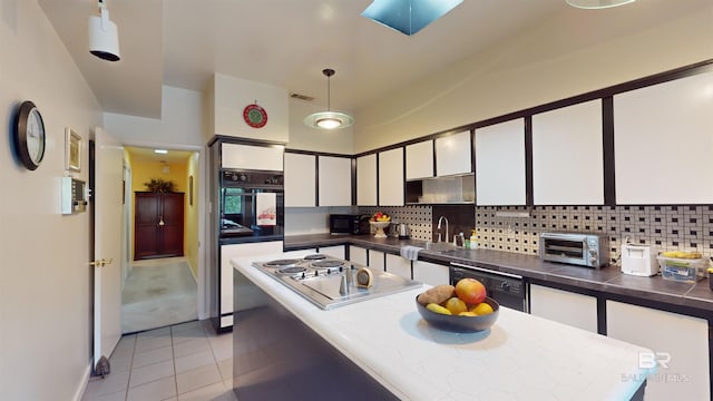 kitchen with white cabinets, decorative light fixtures, decorative backsplash, light tile patterned floors, and black appliances