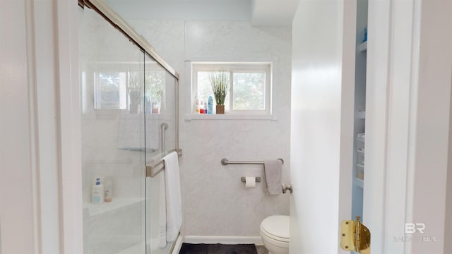 bathroom with toilet and a shower with shower door