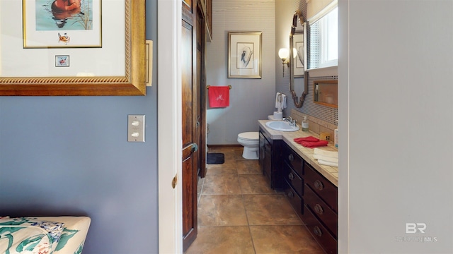 bathroom with toilet, vanity, and tile patterned floors