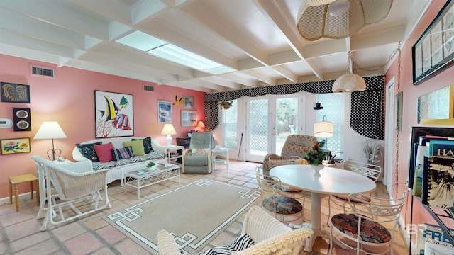 tiled living room featuring beamed ceiling and french doors