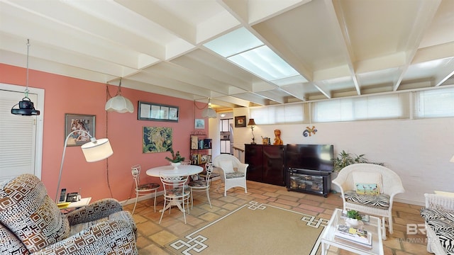 living room featuring beam ceiling, a wealth of natural light, and coffered ceiling