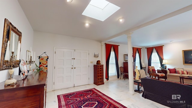 foyer entrance with decorative columns and a skylight