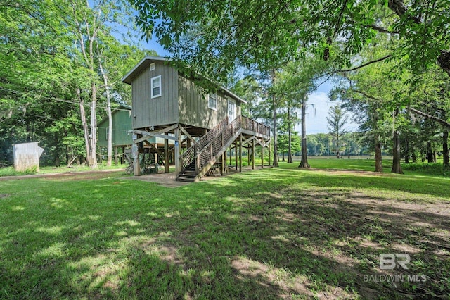 back of property with a deck and a yard