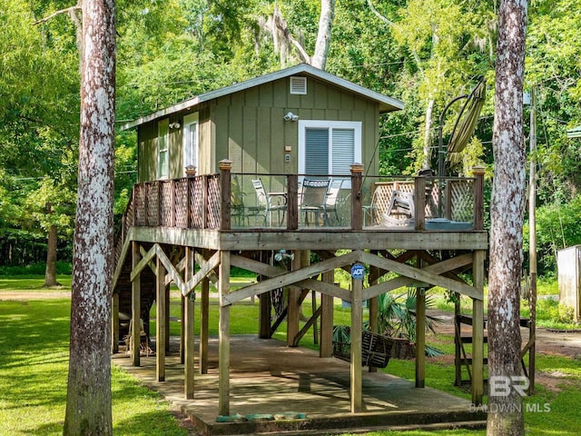 exterior space featuring a wooden deck and a lawn