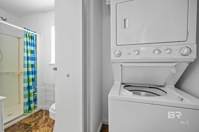 laundry area featuring stacked washer and clothes dryer and tile patterned flooring