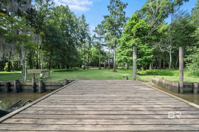 view of dock with a water view and a yard