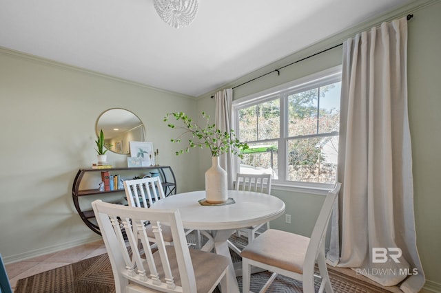 dining room featuring baseboards, crown molding, and tile patterned floors