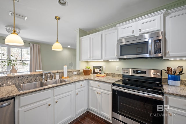 kitchen featuring stainless steel appliances, wood finish floors, a sink, and white cabinetry