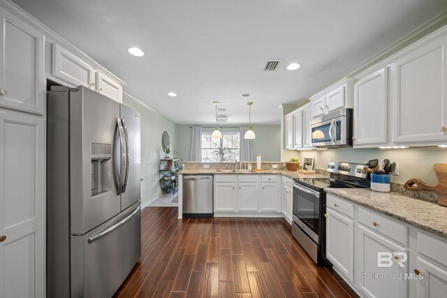 kitchen with dark wood-style floors, a peninsula, appliances with stainless steel finishes, and visible vents