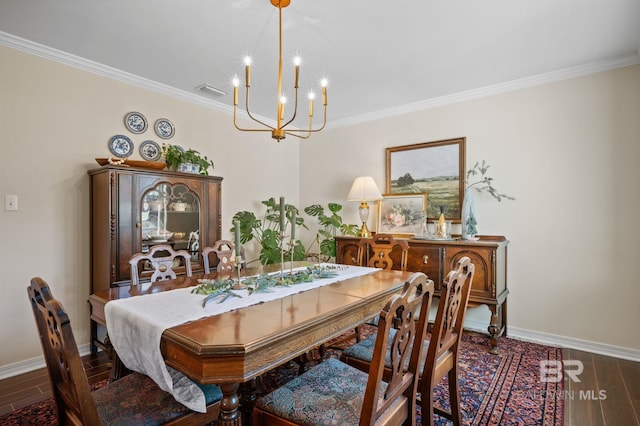 dining room with an inviting chandelier, crown molding, baseboards, and wood finished floors