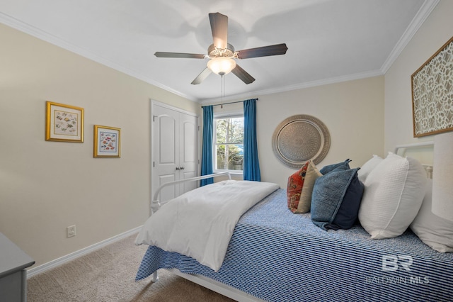 carpeted bedroom with ornamental molding, a closet, ceiling fan, and baseboards