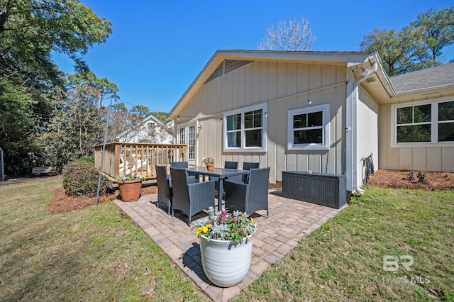 rear view of house with a lawn and a patio