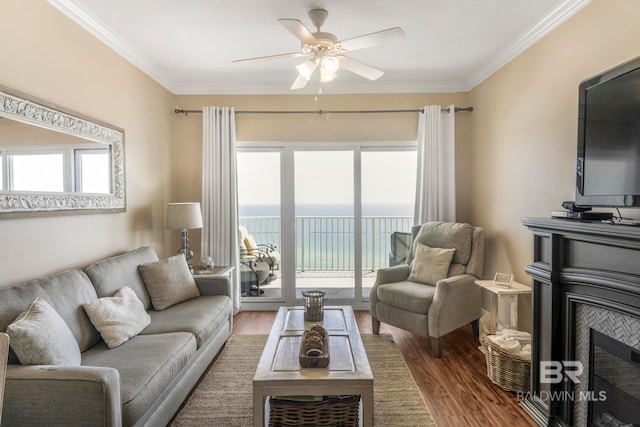 living room featuring crown molding, ceiling fan, wood-type flooring, and plenty of natural light