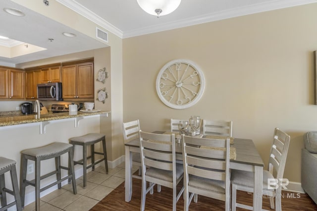401 E Beach Blvd Unit 1704, Gulf Shores, AL 36542 - dining room featuring ornamental molding, baseboards, and light tile patterned flooring