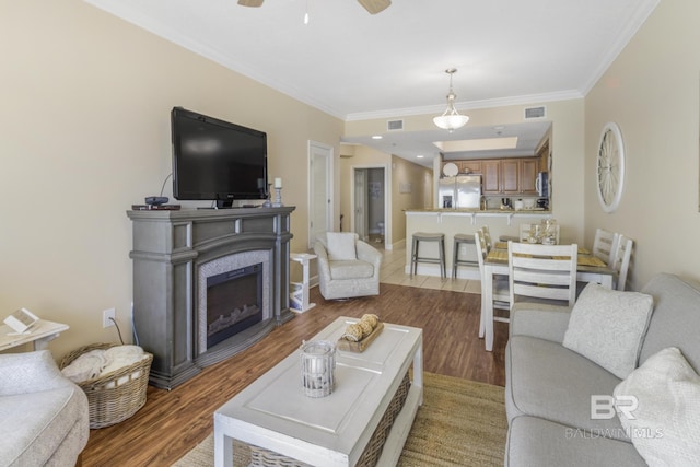 401 E Beach Blvd Unit 1704, Gulf Shores, AL 36542 - living area with ornamental molding, wood finished floors, ceiling fan, a fireplace, and baseboards