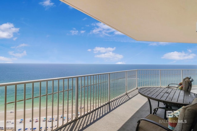 balcony with a water view and a view of the beach