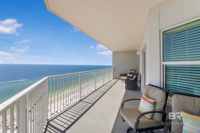 balcony featuring a water view and a beach view