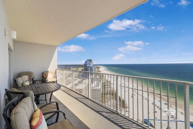 balcony featuring a view of the beach and a water view