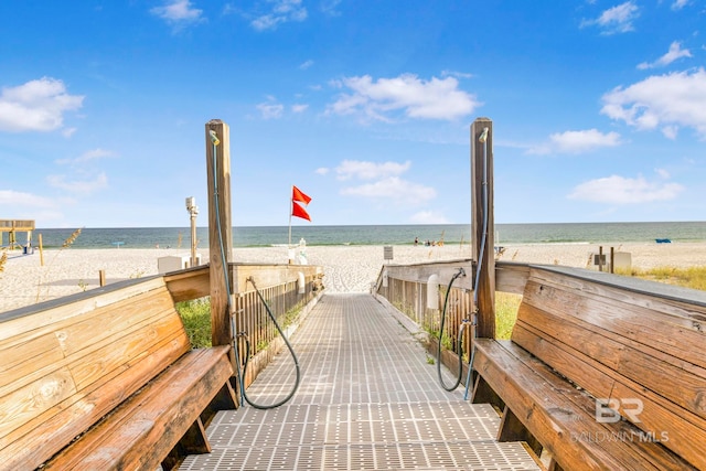 view of home's community with a water view and a beach view