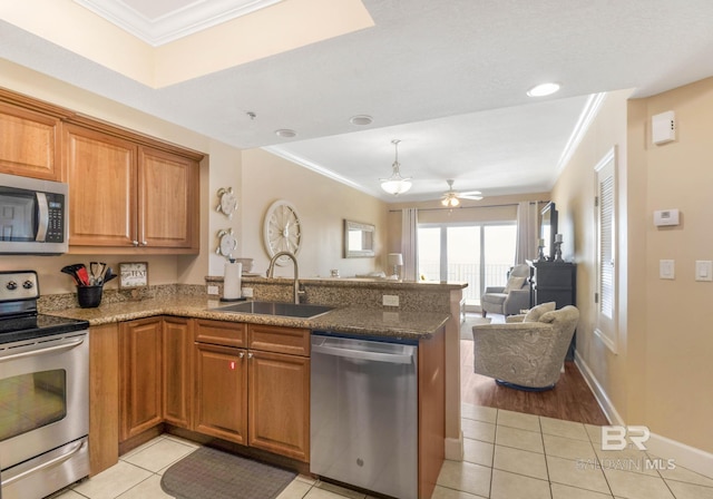 401 E Beach Blvd Unit 1704, Gulf Shores, AL 36542 - kitchen with stainless steel appliances, a sink, light tile patterned floors, a peninsula, and ornamental molding