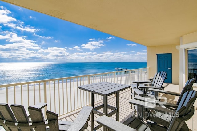 balcony featuring a water view and a view of the beach