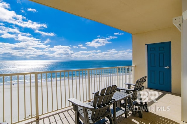balcony featuring a beach view and a water view