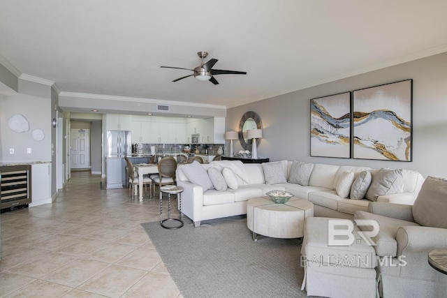 living area with visible vents, ornamental molding, a ceiling fan, beverage cooler, and light tile patterned floors