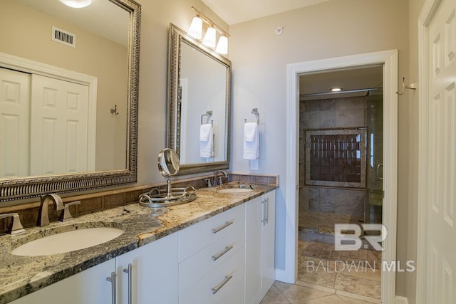 bathroom with a shower stall, tile patterned floors, visible vents, and a sink