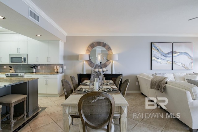 dining space with light tile patterned floors, baseboards, visible vents, ornamental molding, and recessed lighting